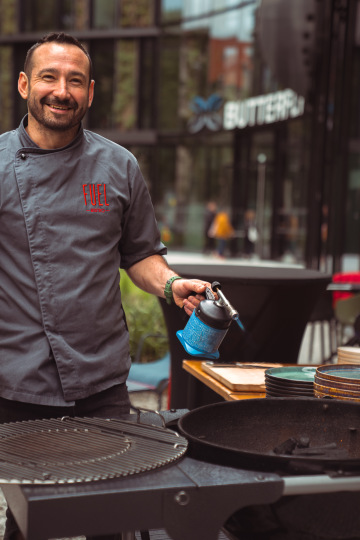usměvavý kuchař u grilu před Fuel bistrem