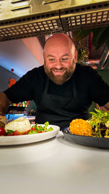 usměvavý číšník servíruje jídla